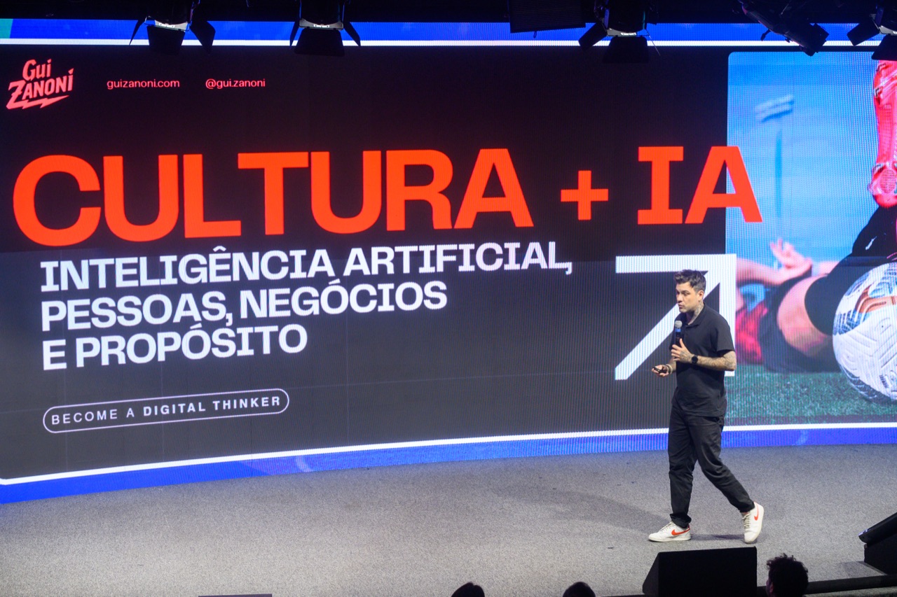 Gui Zanoni no palco com o telão Cultura + IA