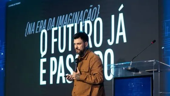 Gui Zanoni no púlpito com o telão O Futuro Já é Passado