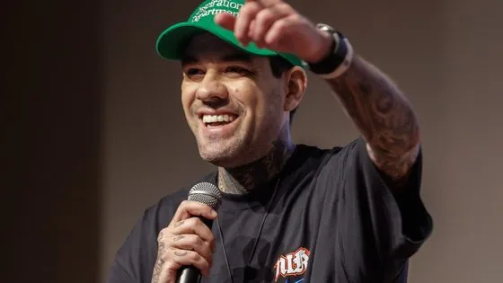 Gui Zanoni sorrindo com microfone durante palestra